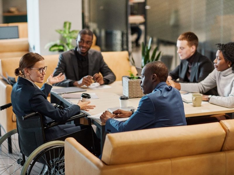 Woman in wheelchair at table in meeting