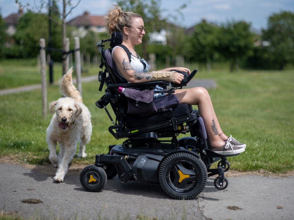 Woman in wheelchair walking dog