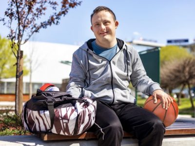 Man outside with sports bag and basketball