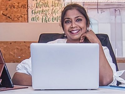 Woman smiling behind laptop