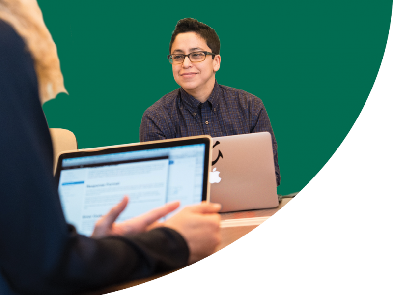 A person in a meeting with glasses and a laptop