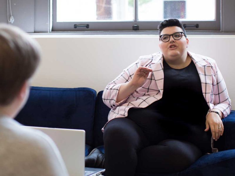 Woman on couch explaining something